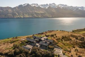an aerial view of a house on a hill next to a lake at Lodge Lorien in Glenorchy