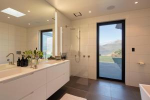 a bathroom with two sinks and a shower and a window at Lodge Lorien in Glenorchy