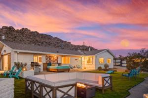 ein Haus mit einer Feuerstelle im Hof in der Unterkunft Neon Moon An Elevated Experience w Pool and Spa in Joshua Tree