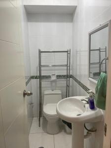 a white bathroom with a toilet and a sink at Hermoso departamento en pueblo libre cerca al aeropuerto in Lima