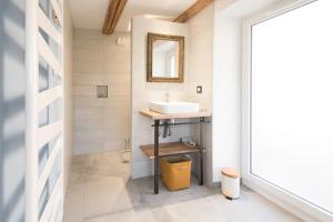 W łazience znajduje się umywalka i lustro. w obiekcie La Loge du Pic Noir w mieście Dabo