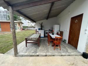 a patio with a table and chairs and a kitchen at Aluguel de mini quartos e barracas no Perequê-açu de frente para o mar numero 1125 in Ubatuba