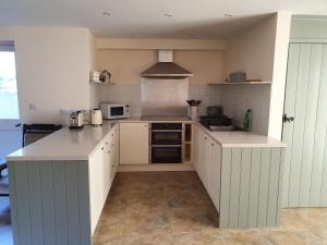 a kitchen with white cabinets and a counter top at Villa Muneera - rural retreat in the heart of Pembrokeshire in Narberth