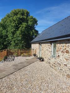a stone building with a wooden walkway in front of it at Villa Muneera - rural retreat in the heart of Pembrokeshire in Narberth