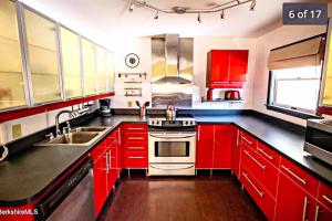 uma cozinha com armários vermelhos e um forno com placa de fogão em Gorgeous Ski On/Off 2 BR Sleeps 8 Jiminy-Must See Luxury em Hancock