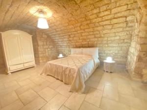um quarto com uma cama numa parede de pedra em Dimora Pietra Antica em Bari