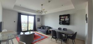 a living room with a glass table and a dining room at Stylish One bedroom with all amenities, close to downtown1 in Dubai