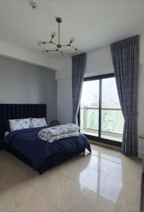 a bedroom with a bed and a large window at Stylish One bedroom with all amenities, close to downtown1 in Dubai