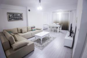 ein Wohnzimmer mit einem Sofa und einem Tisch in der Unterkunft GRANDE APARTMENT KORCE in Korçë