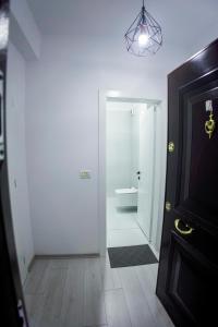 ein weißes Bad mit WC und Tür in der Unterkunft GRANDE APARTMENT KORCE in Korçë