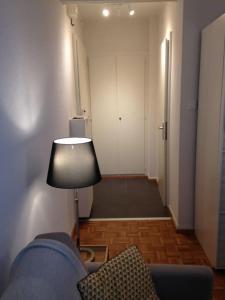 Cette chambre dispose d'un canapé, d'une lampe et d'un couloir. dans l'établissement Beautiful studio 2 minutes from the train station, à Lausanne