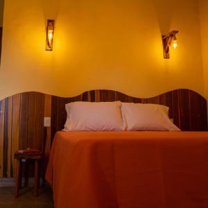 アウト・パライーゾ・デ・ゴイアスにあるEspaço Canela-de-Emaの黄色い壁のドミトリールームのベッド1台分です。