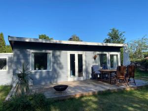 Casa con terraza con mesa y sillas en Sommerhus i Bjerge Nordstrand tæt ved havet, en Store Fuglede