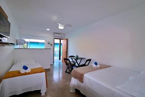 um quarto de hotel com duas camas e uma mesa em Búzios Conforto Guest House - 450 metros Rua das Pedras em Búzios