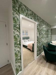 a bedroom with a bed with green leaves on the wall at Private Modern Apartment in Olton