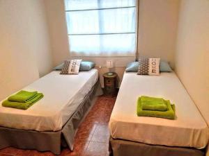 a bedroom with two beds with green towels on them at Apartamento en la entrada del barrio antiguo in Córdoba