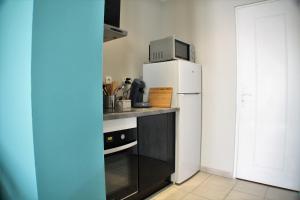 małą kuchnię z lodówką i kuchenką mikrofalową w obiekcie Le Cottage des Curie w Calais +22 zdjęcia