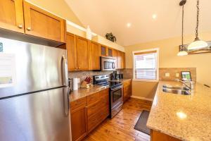 a kitchen with a stainless steel refrigerator and wooden cabinets at Lake View! Steps to the Pool! Pet Friendly! 