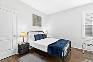 a white bedroom with a bed and a window at Lovely two-bedroom relaxing private parking Townhome rental in Detroit