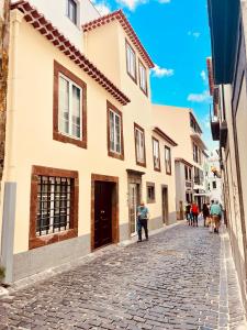 eine Kopfsteinpflasterstraße in einer Stadt mit Gebäuden in der Unterkunft Living Funchal X in Funchal