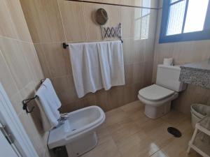 a bathroom with a white toilet and a sink at VILLA BARRACUDA - "Seaview 3min walk to the beach" in Playa Blanca