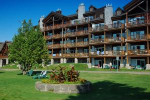 a large apartment building with a park in front of it at Le Grand Lodge Mont Tremblant in Mont-Tremblant