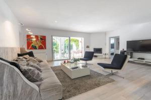 uma sala de estar com um sofá e cadeiras e uma televisão em Villa Can Cozy em Cidade de Ibiza