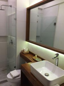 a bathroom with a sink and a glass shower at Hotel Pelecanus Suites Holbox in Holbox Island