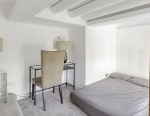 a bedroom with a bed and a desk with a chair at Penthouse Apartment in London