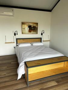 a bedroom with a large bed with white sheets at Hoxhohl Travel Lodge in Colonia del Sacramento