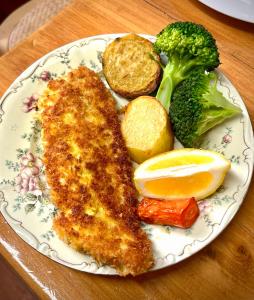 a plate of food with fish and broccoli and potatoes at The Old Eltham Post Office in Eltham
