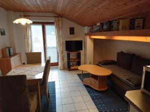 uma sala de estar com um sofá e uma mesa em Haus-Brecherspitzblick em Schliersee