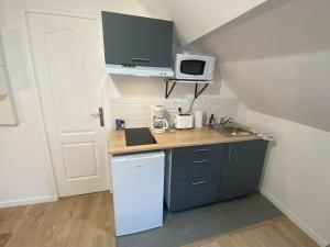 a small kitchen with a sink and a refrigerator at Cattleya location in Vierzon