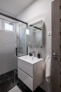 a bathroom with a white sink and a shower at Balatonic Relax in Zamárdi