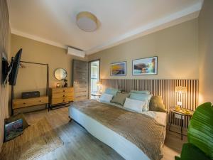 a bedroom with a large bed and a television at Balatonic Relax in Zamárdi