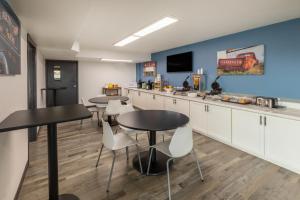 a kitchen with two tables and chairs and a tv at Baymont by Wyndham Laredo in Laredo