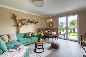 a living room with a green couch and a table at Balatonic Relax in Zamárdi