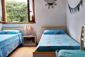 sypialnia z 2 łóżkami i oknem w obiekcie Villa Fronte Mare w mieście Stintino
