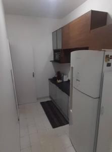 a kitchen with a white refrigerator and wooden cabinets at Ap grande e ultramoderno e no ponto estratégico de Copacabana in Rio de Janeiro