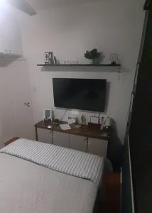 a bedroom with a bed and a desk with a television at Ap grande e ultramoderno e no ponto estratégico de Copacabana in Rio de Janeiro