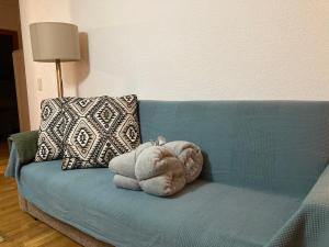 un animal de peluche está sentado en un sofá azul en Apartamento LA MOLINA, en Alp
