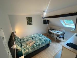 - une petite chambre avec un lit et une table dans l'établissement Cattleya location, à Vierzon