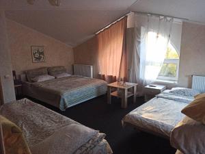 Una habitación de hotel con dos camas y una ventana. en Готель Жасмин, en Ternopilʼ