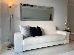 a white couch with pillows on it in a living room at Hollywood on Beach Apartment in Hollywood