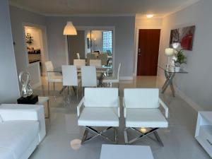 a living room with white chairs and a table at Hollywood on Beach Apartment in Hollywood