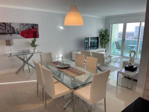 a dining room with a glass table and chairs at Hollywood on Beach Apartment in Hollywood
