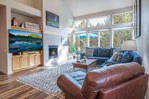 雷德蒙德Whispering Creek - Meredith Lodging的带皮沙发和壁炉的客厅