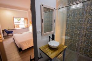Habitación con baño con ducha y lavabo. en Hotel Pajara Pinta, en Cali