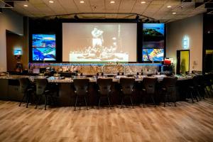 a large conference room with a long table and two screens at The Federal Hotel Downtown Carson City, an Ascend Collection Hotel in Carson City
