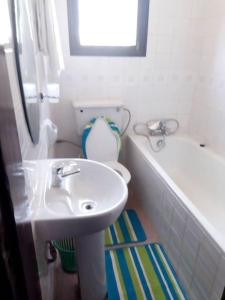a white bathroom with a sink and a toilet at Larry's Place in Kampala